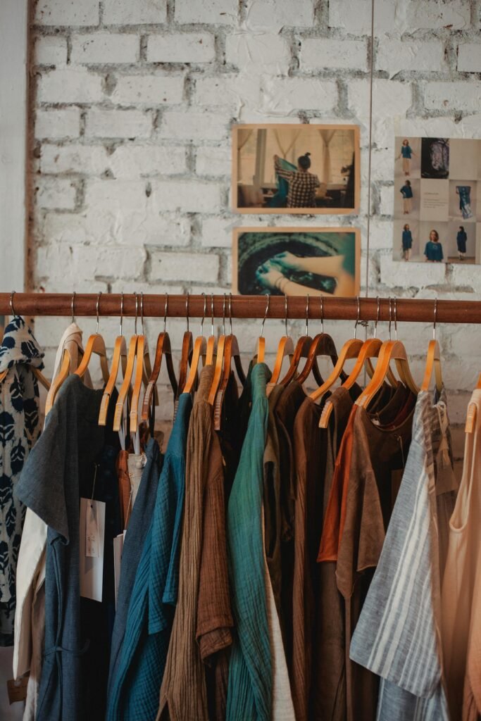 pexels-photo-5709661-5709661-1 Colorful assortment of clothes on wooden hangers in a trendy boutique.
